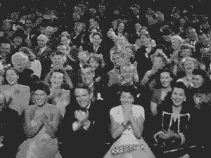 Fragmento de video en blanco y negro de personas aplaudiendo en un teatro